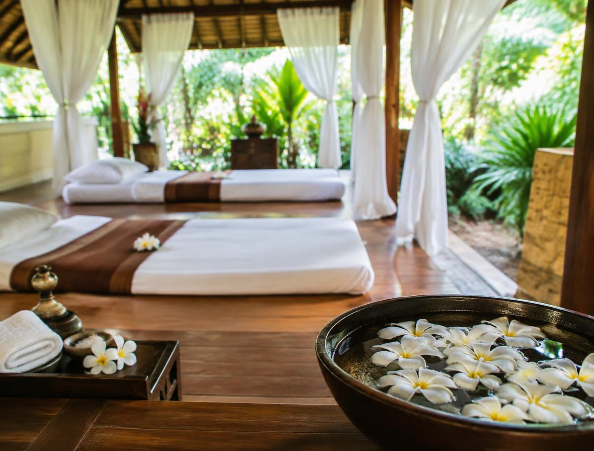 Thai spa pavilion with massage beds and frangipani flowers